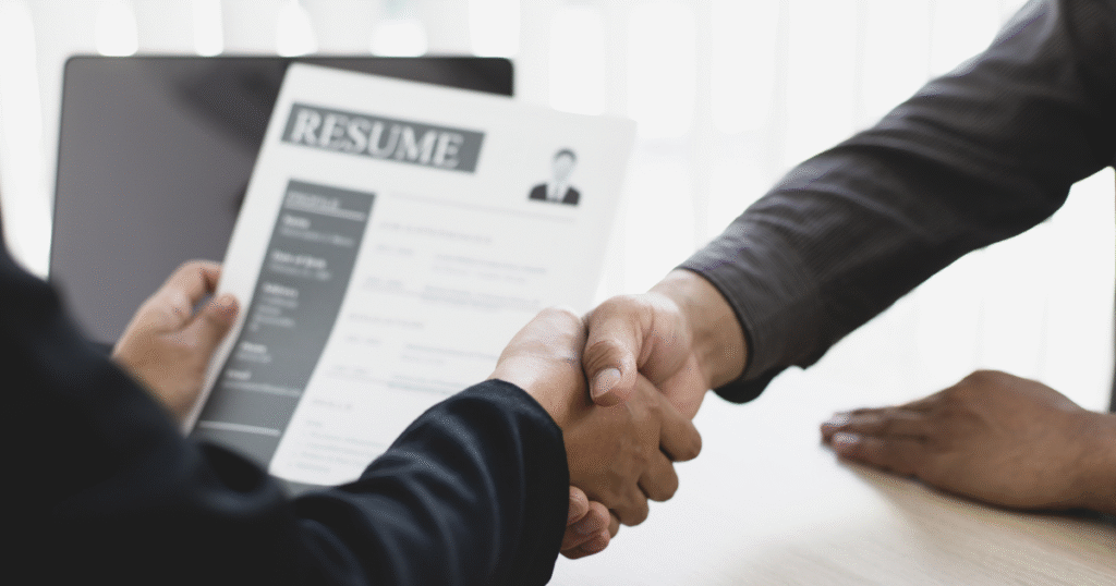 Candidate shaking hands with a recruiter after a successful interview, representing placement guarantee and career opportunities.